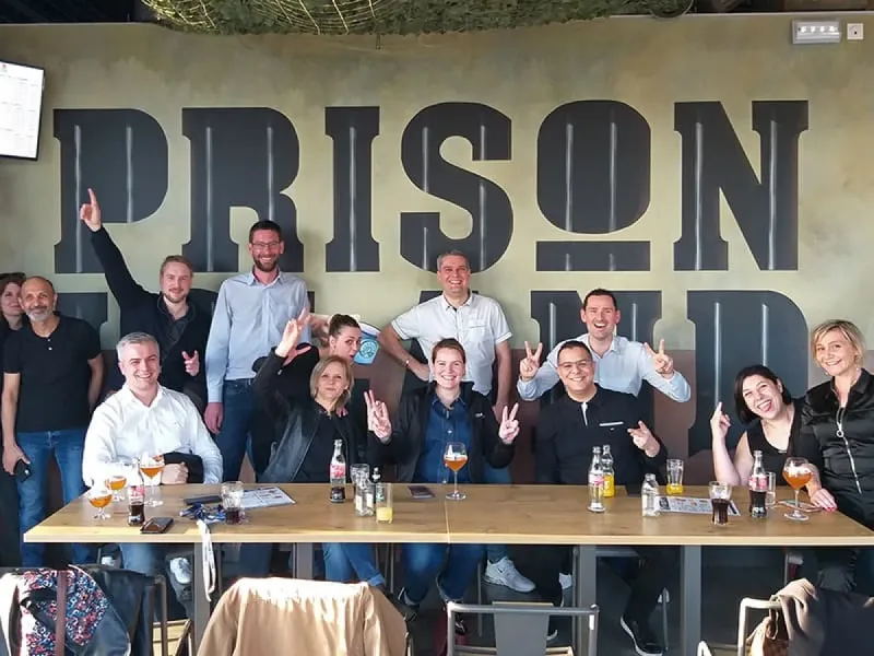 Un groupe attablé au bar, sous le mur Prison Island